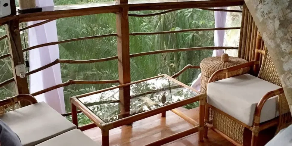 The cradle treehouse interior seating area with small table at the treehouse lodge in peru.